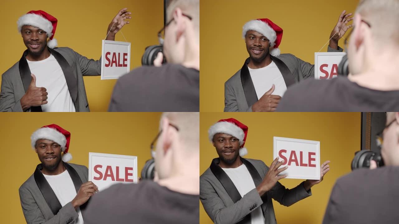 幕后拍摄一名戴着圣诞帽的黑人男子，上面标有 “sale” 字样