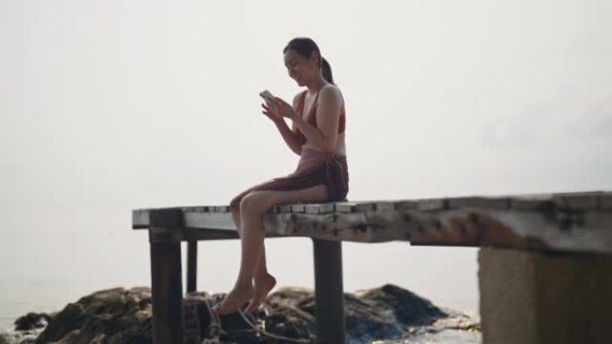 女人放松并在智能手机上使用应用程序