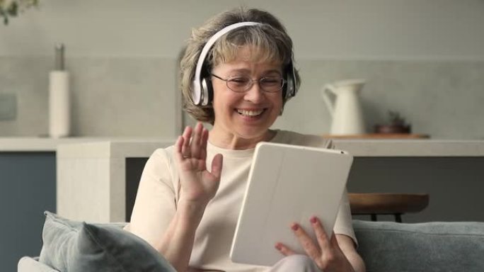 笑着退休的女性使用pad通过视频与朋友交谈