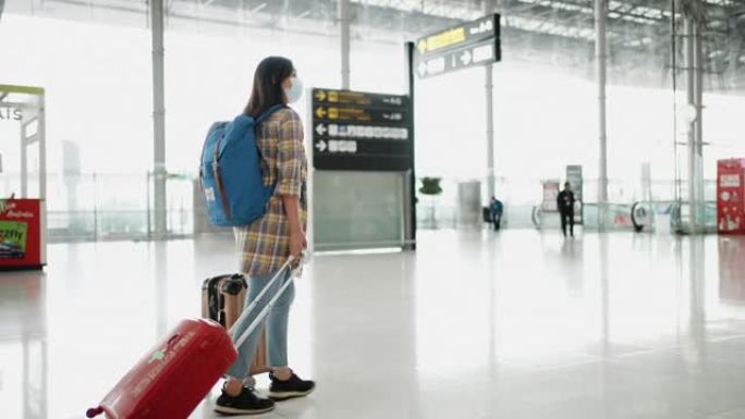 在航站楼机场的登机口散步的旅游妇女
