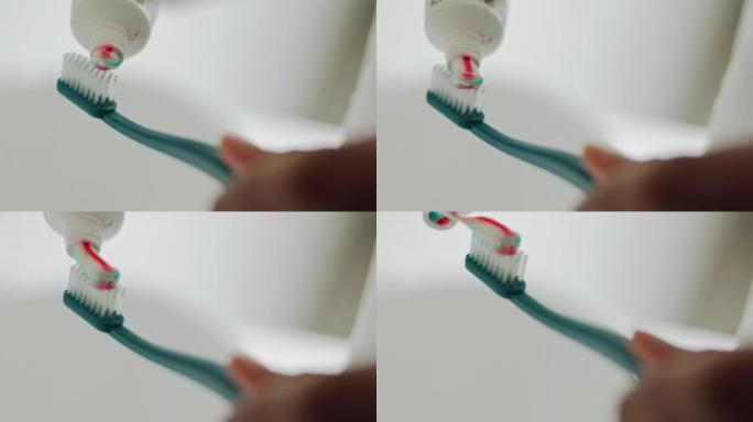 牙刷上的牙膏手，早上的口腔卫生和清洁牙齿，健康和牙齿保健在家里的浴室。放大口腔清洁、美容和健康自我护