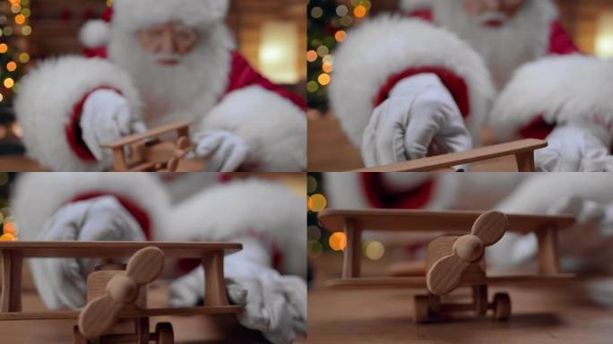 圣诞老人玩可爱的木制飞机，把它放在桌子上，我们特写镜头