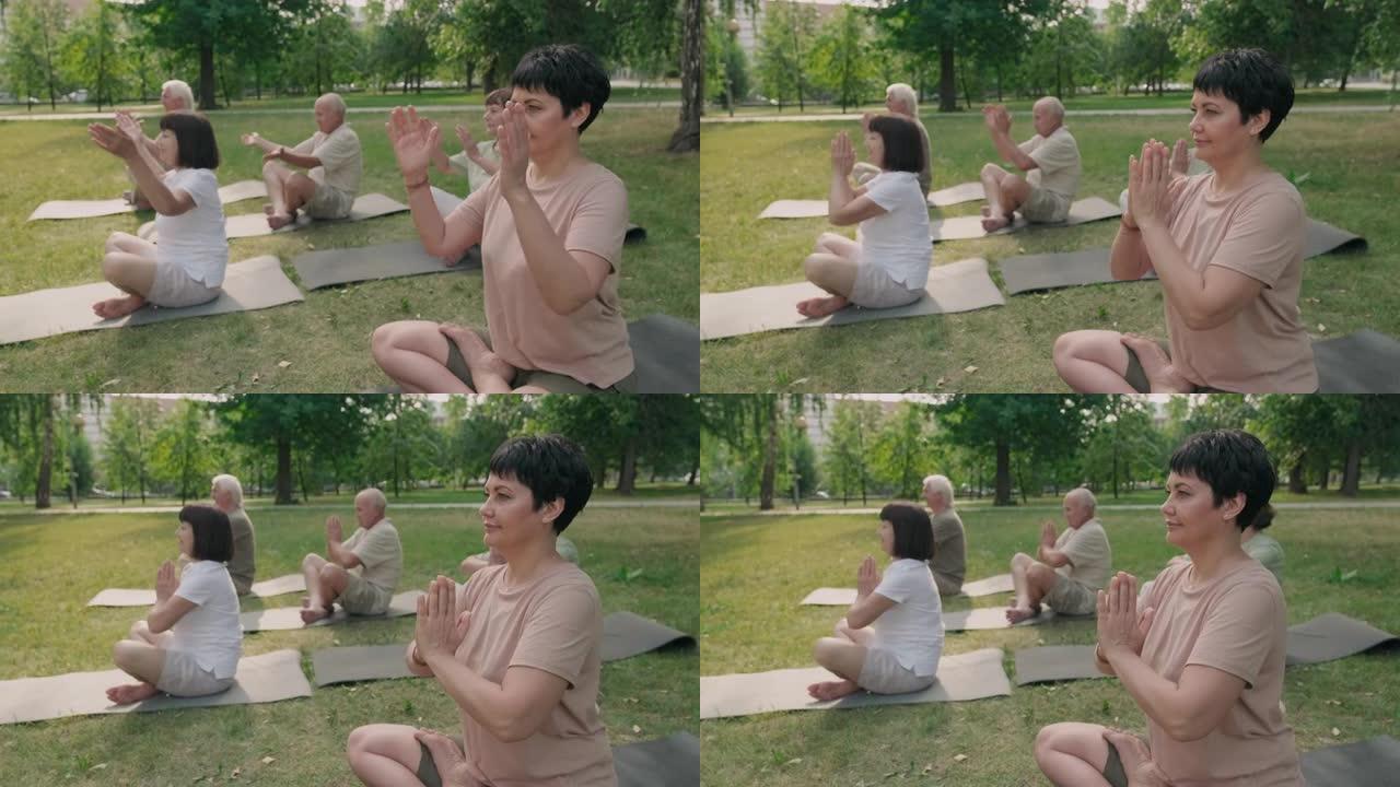 女教练在公园与老年人一起做瑜伽