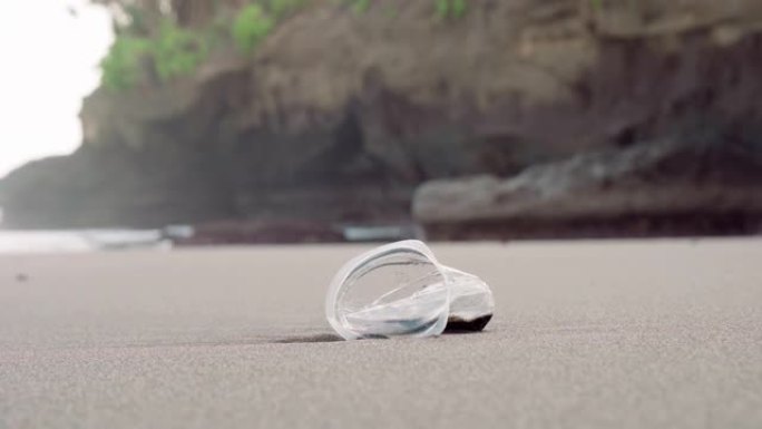 海滩上留下的皱巴巴的塑料杯