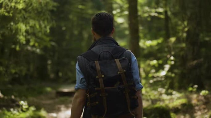 背着背包走在森林里的男人