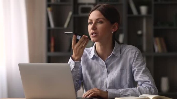 女商人使用智能手机和免提电话与客户远距离交谈