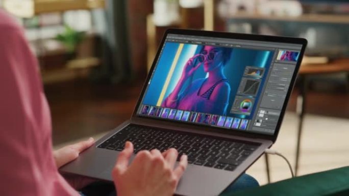 人使用笔记本电脑使用模拟软件编辑图像。动画与时尚摄影项目与模型在霓虹灯，用户界面。电脑显示器，笔记本