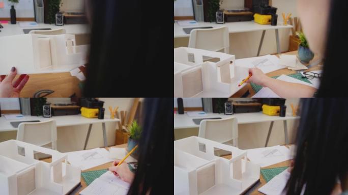 女性建筑师在办公桌上研究建筑模型和测量计划的视点镜头 -- 慢动作镜头