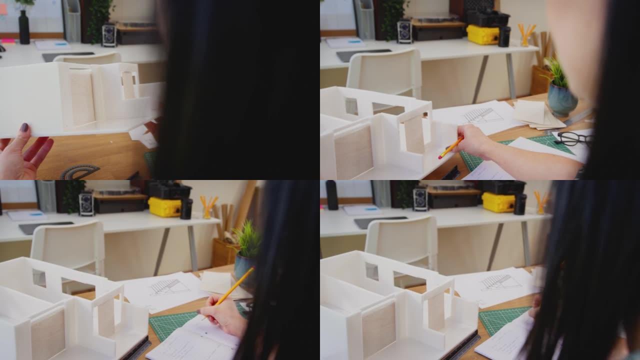 女性建筑师在办公桌上研究建筑模型和测量计划的视点镜头 -- 慢动作镜头