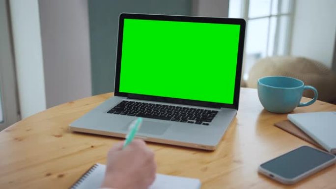 男人看着工作笔记本电脑上的绿屏。办公室人员使用绿屏笔记本电脑。盖伊在工作场所环境中使用色度键模型学习