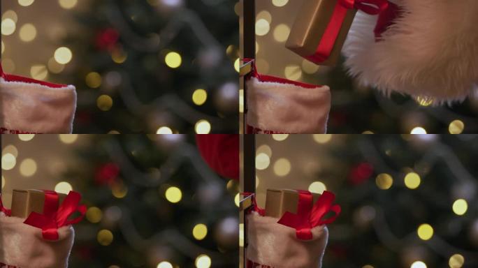 圣诞老人的手的特写镜头，将礼物放在圣诞节袜子中