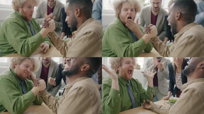 有趣的年轻人在工作场所享受手臂摔跤比赛