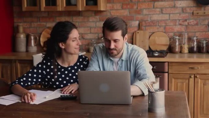 已婚夫妇用笔记本电脑上的网银应用支付每月账单