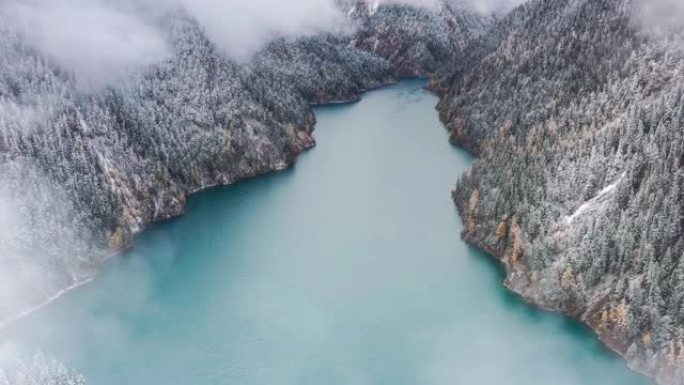 像碧玉一样的湖泊镶嵌在云雾雪林中