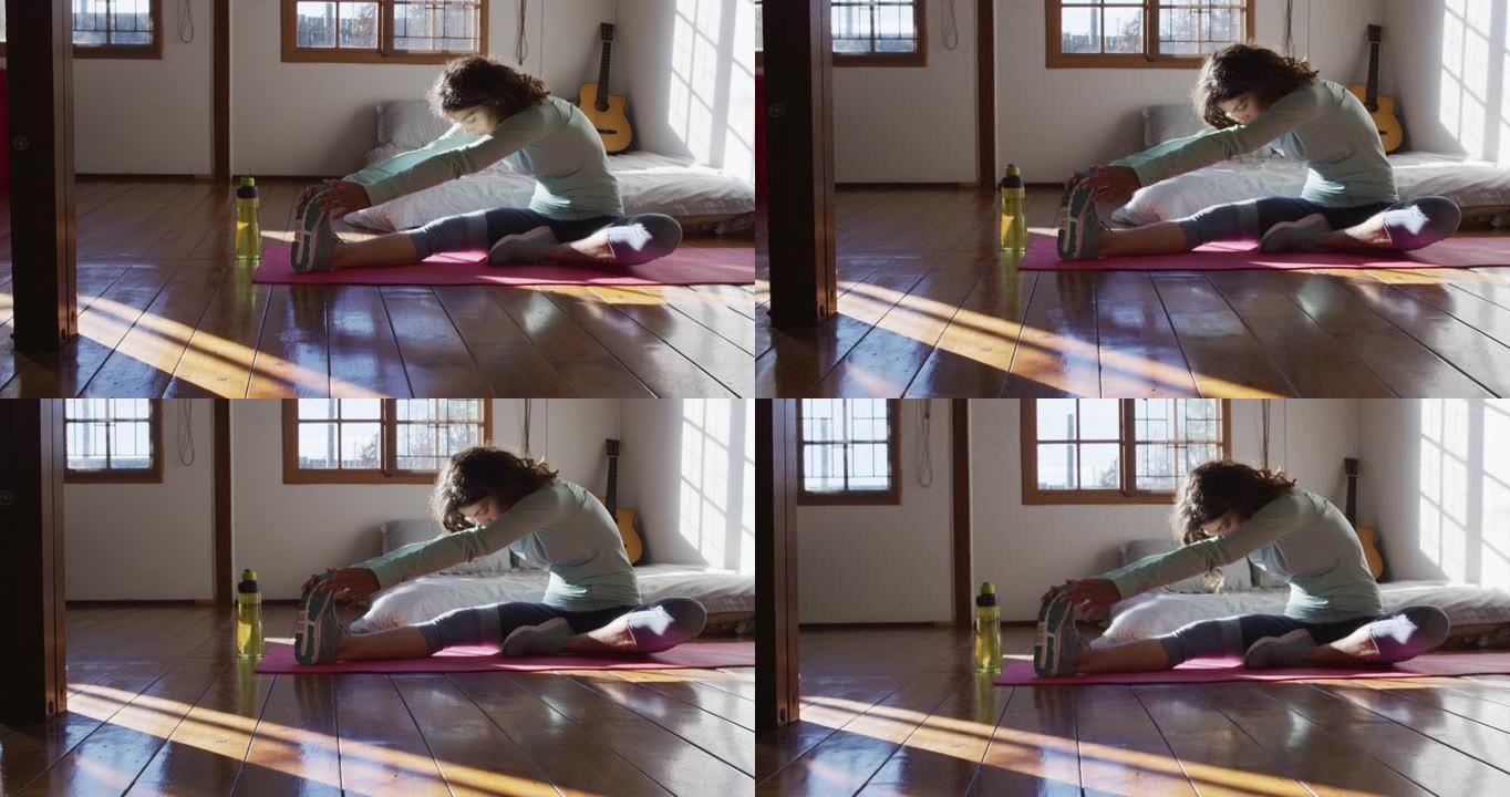 健康的混血妇女在小屋卧室锻炼、坐着和伸展