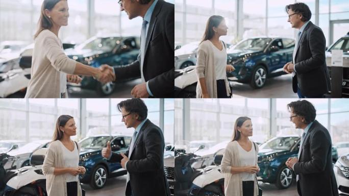 SLO MO汽车推销员交出钥匙并与一位女顾客握手