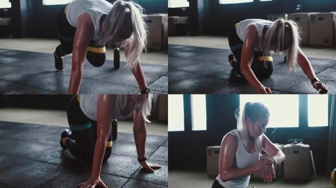 健身器材。美丽的运动出汗的女人在现代健身房做运动，使用智能手表移动应用程序跟踪器。