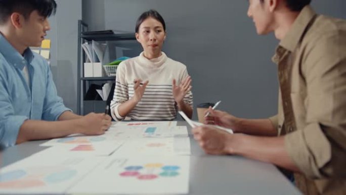 亚洲商人和女企业家会集思广益，向他的合作伙伴共同规划成功战略，在小型现代家庭办公室享受团队合作。
