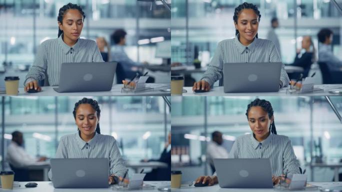 多种族办公室: 专业的黑人女性IT工程师，在笔记本电脑上的台式机上工作。成功的，微笑的辫子女商人做创