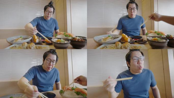 亚洲男子在日本餐厅吃三文鱼生鱼片