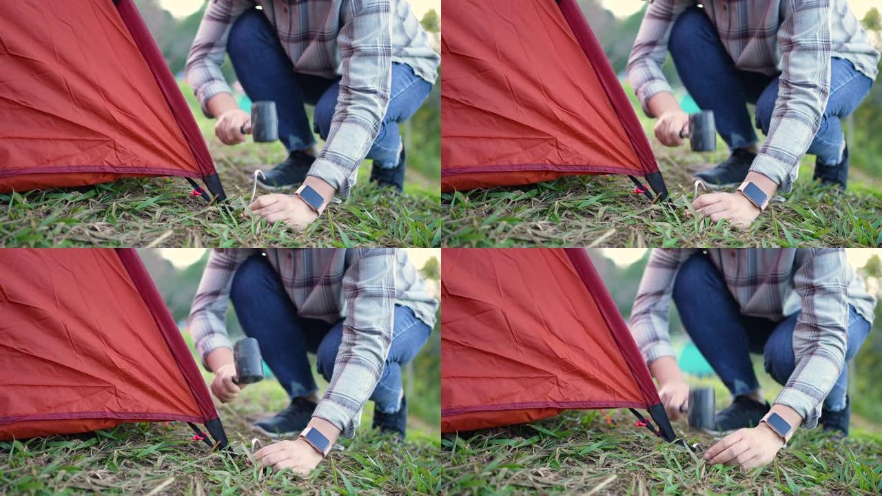 女旅行者在山上的露营地搭建帐篷