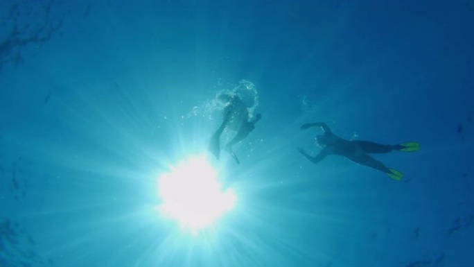 女士夫妇在克罗地亚阳光明媚的亚得里亚海水下浮潜