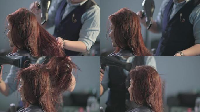 美发沙龙亚洲中国女性发型师吹梳湿长发为她的顾客在美发沙龙