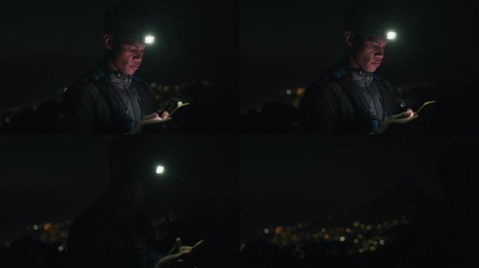 4k视频片段，一名男子戴着头灯，晚上在外面使用手机