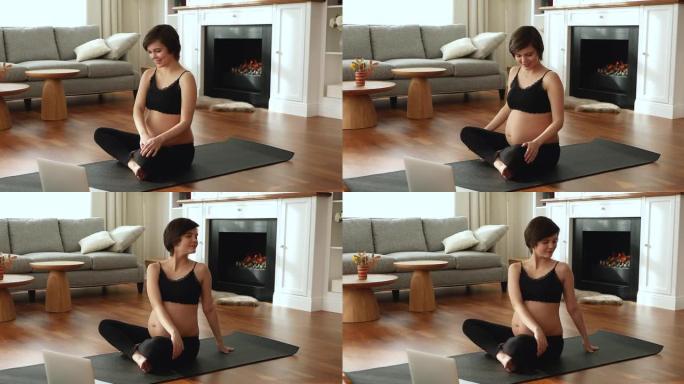 孕妇使用笔记本电脑观看在线训练重复瑜伽体式