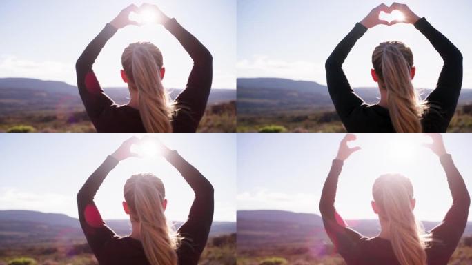 4k视频，一个女人用手在山上做心形