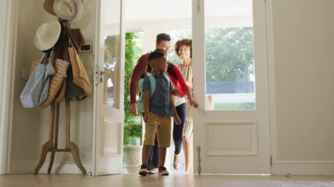 快乐的非裔美国人家庭从前门进入房屋