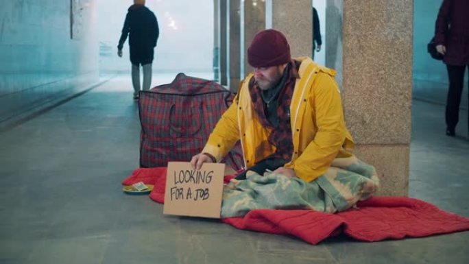 一个乞丐正在通知路人他正在找工作