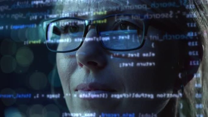 女性创业数字企业家在电脑上工作的肖像，一行代码投射在他的脸上，并在眼镜中反射。开发人员使用AI和大数