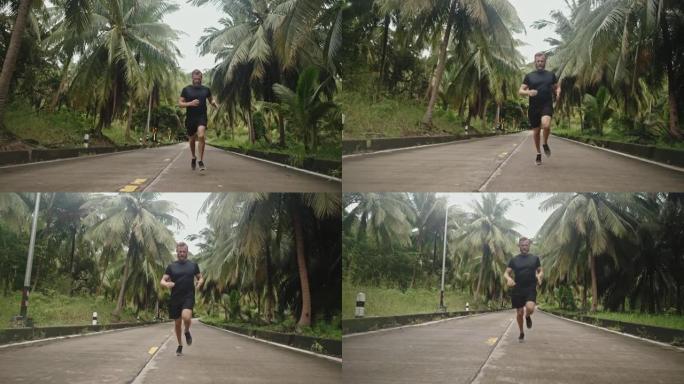 男子在路上奔跑热带风景区林间公路跑步健身