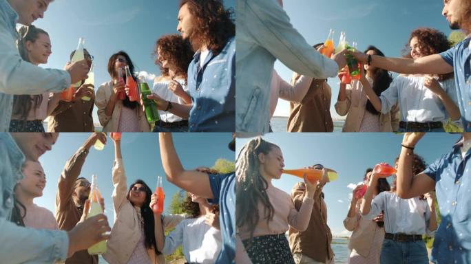 快乐的朋友在海滩上碰碰瓶子和喝酒的慢动作肖像