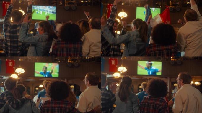 一群足球迷在体育酒吧直播足球比赛时欢呼、尖叫、举手和跳跃。穿着蓝色衬衫的球员进球，朋友们庆祝。慢动作