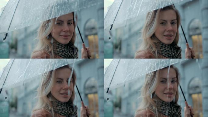 在城市里，白天下雨时，特写肖像女人在伞下，笑容灿烂。休闲女性喜欢户外城市生活背景下的秋天滴。漂亮的眼