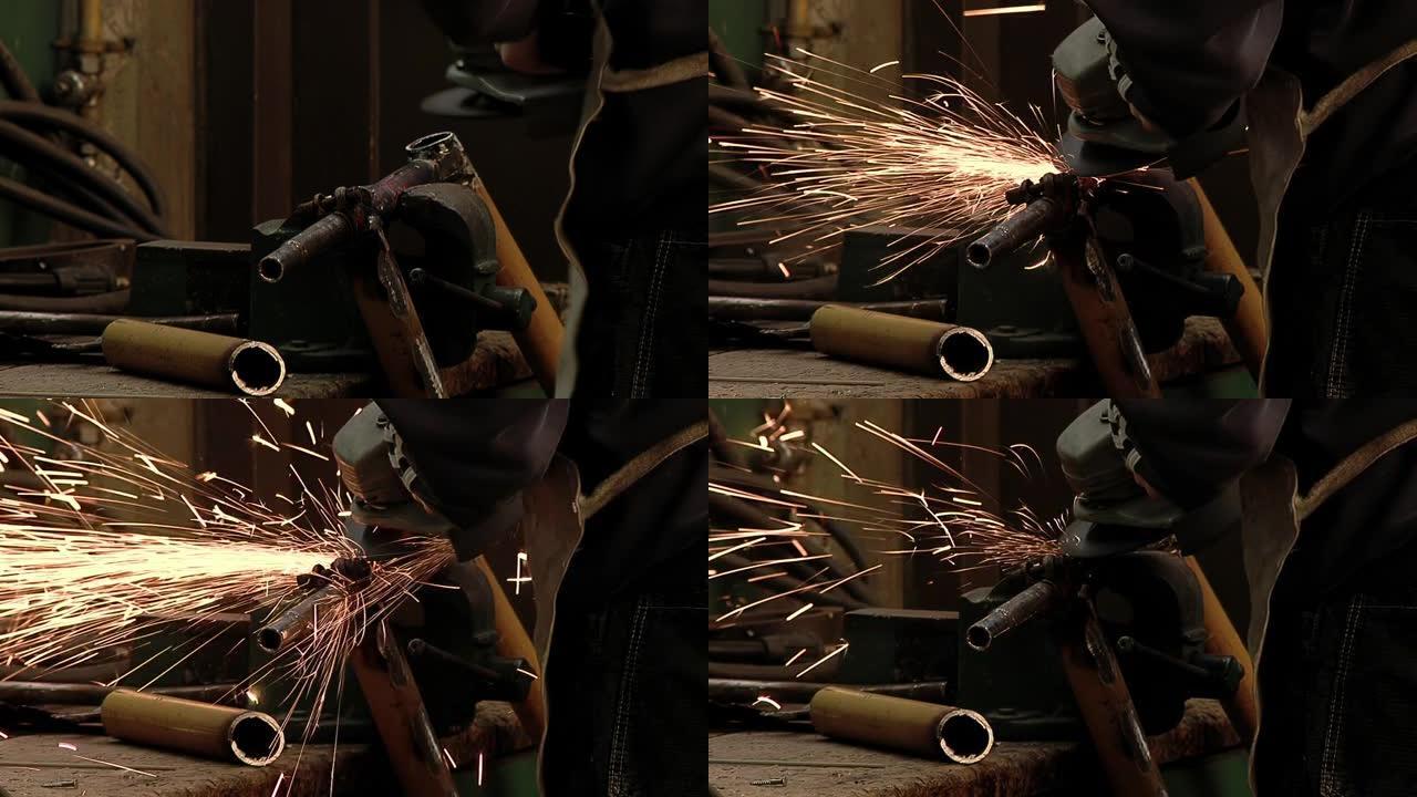 一个人用研磨机切割金属棒，用角磨机加工金属。特写。