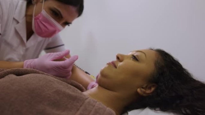 水疗中心的非裔美国妇女在下巴接受脂肪燃烧注射治疗
