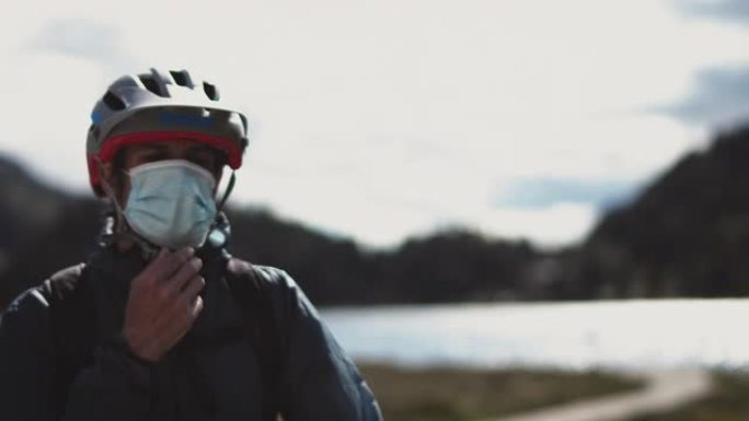 新型冠状病毒肺炎期间戴防护面具骑自行车的人