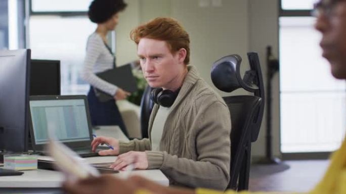 高加索创意商人在现代办公室使用计算机的肖像
