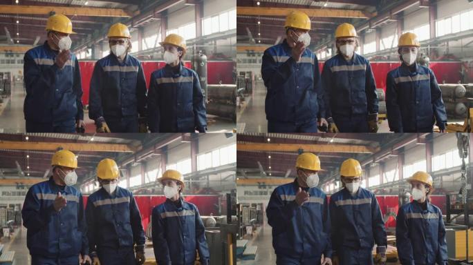 戴着口罩的主管和工人穿过工厂设施