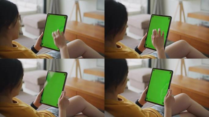 女人在家中使用带有绿屏的数字平板电脑