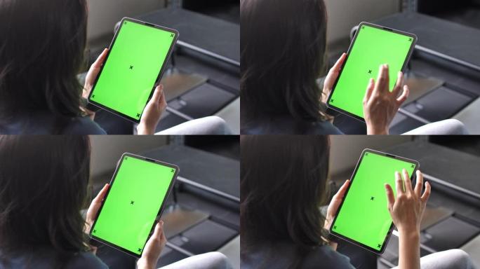 使用绿屏数字平板电脑的年轻女子