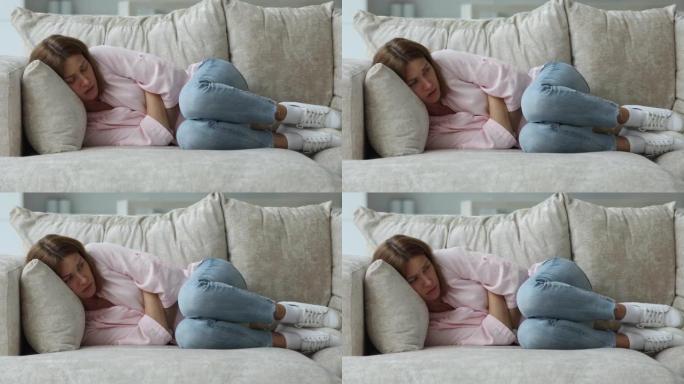 女人经历月经疼痛，躺在沙发上看起来不健康