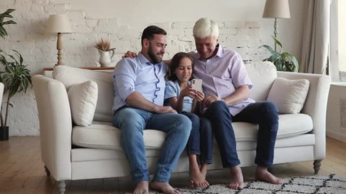 小男孩他的祖父和父亲喜欢周末使用智能手机