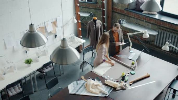 裁缝男女在工作室聊天制作新衣服的俯视图