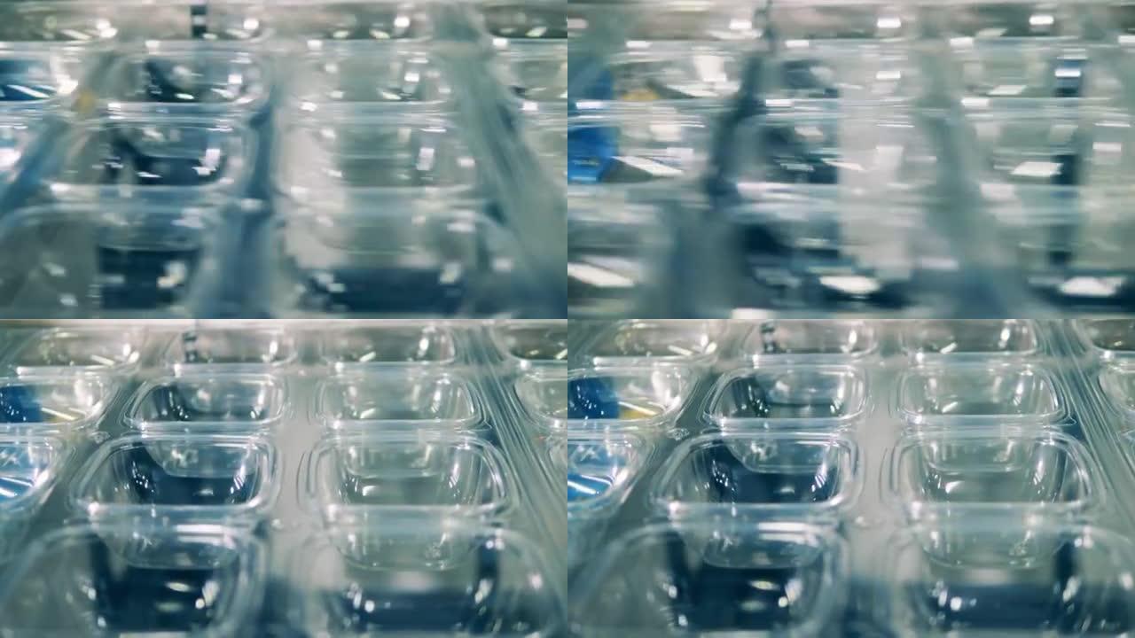 塑料生产，聚合物回收厂。透明塑料容器生产线特写
