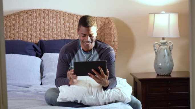 男人在床上使用平板电脑，女人加入，向他展示她的手机