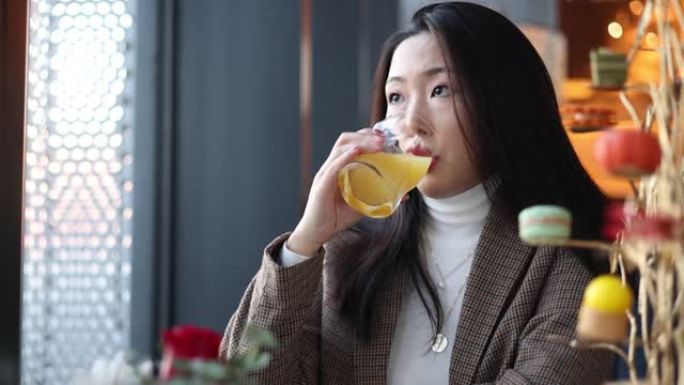 年轻女性喝一杯橙汁